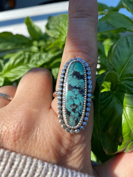 One of a kind handcrafted ring.  Eye-catching natural turquoise oblong stone set in a decorative sterling silver ring. What a stunner!  Available in US size 10 for a perfect pointer finger fit.  Turquoise, the captivating sea-green stone of the ancients, represents wisdom, tranquility, protection, good fortune, and hope.  Ships out within 1 to 2 business days. (Not including weekends or holidays)