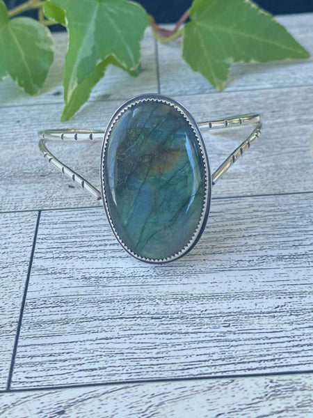  One of a kind handcrafted bracelet.  Sterling silver cuff bracelet set with a gorgeous natural green and blue labradorite stone.   Ships within 1 to 2 business days. (Not including weekends or holidays)  The Labradorite encourages you to go after your dreams, and helps you get out of your own way so you can make your dreams come true.