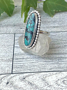 One of a kind handcrafted ring.  Eye-catching natural turquoise oblong stone set in a decorative sterling silver ring. What a stunner!  Available in US size 10 for a perfect pointer finger fit.  Turquoise, the captivating sea-green stone of the ancients, represents wisdom, tranquility, protection, good fortune, and hope.  Ships out within 1 to 2 business days. (Not including weekends or holidays)