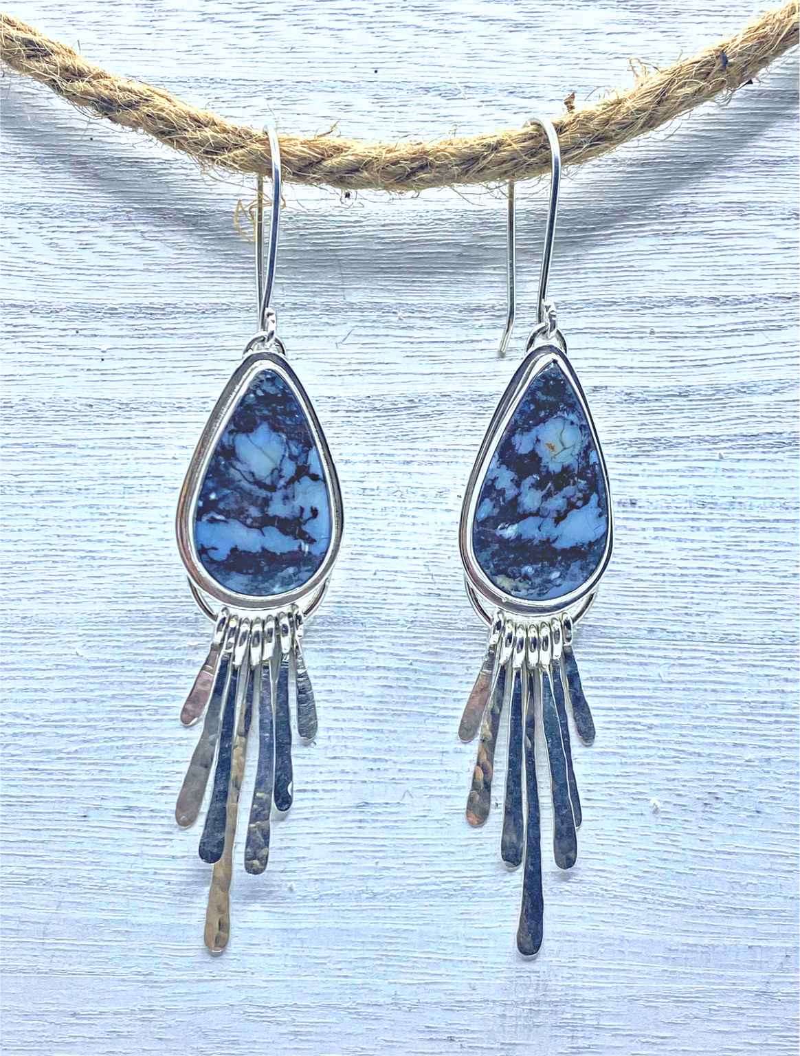 One of a kind handcrafted earrings.  Beautifully handcrafted sterling silver dangle earrings, set with natural Wild Blue stones. Each individual silver dangle was forged and textured by hand.  Ships within 1 to 2 business days. (Not including weekends or holidays)  Wild Blue is said to reduce anger and increase consiousness. Wild Blue is a stone of good fortune and blessing.